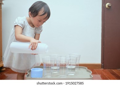 Cute Asian Toddler Girl Having Fun Playing With Water Table At Home, Wet Pouring Montessori Preschool Practical Life Activities, Fine Motor Skills Development - Selective Focus At Kid's Left Eye