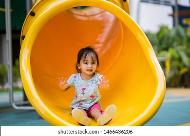 Cute Asian toddler girl playing at the slider in the playground. - Shutterstock ID 1466436206