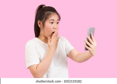 Cute Asian Woman Holding Smart Phone In Hand, Get Surprised And Excited, Suprise Feeling, Winner Expression, White Shirt, Pink Background