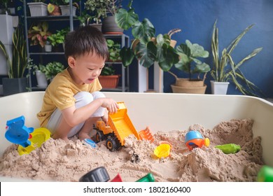 Cute Asian Young Boy Playing With Sand Alone At Home, Kid Playing With Sand Toys & Toy Construction Machinery In Urban Home Garden , Montessori Education, Creative Play For Kids Concept