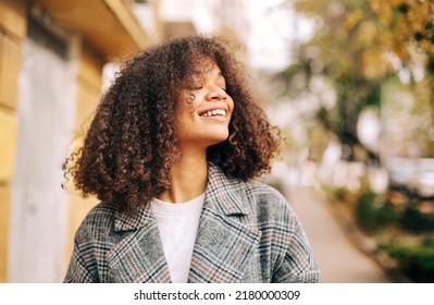 Cute Autumn Close Up Portrait Of Young Smiling Happy African American Woman With Curly Hair Enjoying Walk In Park In Fall Season. Outdoor Photo Of Pleased Black Girl With Eyes In Love With Life