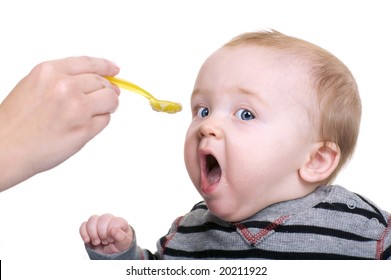 Cute Baby Being Feed Rice Cereal With A Yellow Spoon