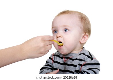 Cute Baby Being Feed Rice Cereal With A Yellow Spoon