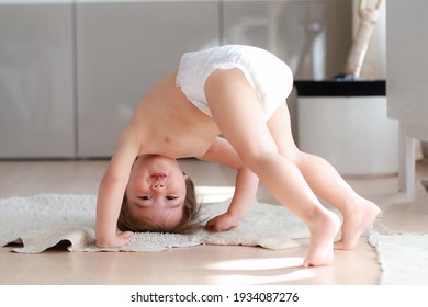 Cute baby boy bending over doing yoga at home. Mixed race Asian-German infant play and learning development. Happy and funny kid.