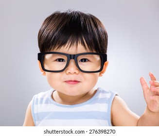 Cute Baby Boy With Black Glasses And Hand Raised Up