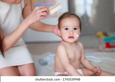 Cute Baby Boy Brushing A Hair By His Mother After Shower And Applying Lotion Cream To Protect Skin On Face And Body.mixed Race Asian-German Infant  Combing Relaxing After Bathing With His Mommy