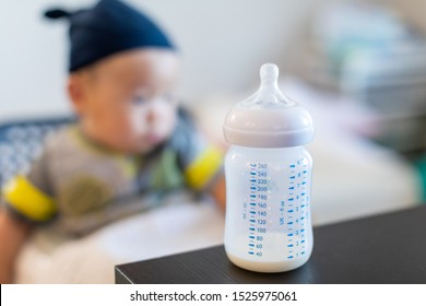 Cute baby boy drinking from bottle. Focus on bottle