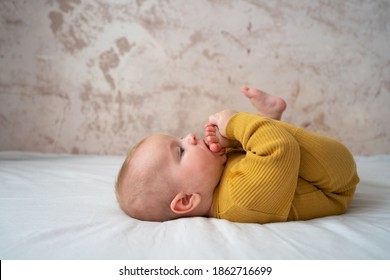 Cute Baby Boy With Foot In His Mouth, Tasting Toes