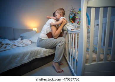 Cute baby boy got scared at night at hugging young caring mother - Shutterstock ID 470837768