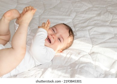 Cute Baby Boy Lies On Bed On Tummy Or Back.toddler Is Relaxed,angry,cry Out,nervous Or Drinks Water From Plastic Bottle.morning Sun Rays Fall On Infant Face.curious Kid,maternal Love Care Warm Secure 