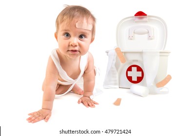 Cute Baby Boy Playing With Bandages In A First Aid Kit Box.