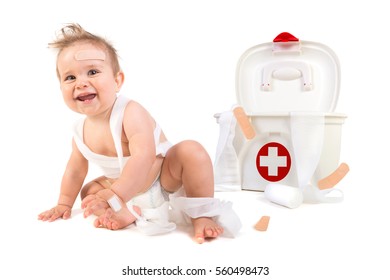 Cute Baby Boy Playing With Bandages In A First Aid Kit Box.