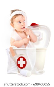 Cute Baby Boy Playing With Bandages In A First Aid Kit Box.