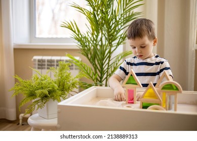 Cute baby boy playing sand table therapy toys developing game at home. Confident male kid building construction with playthings enjoying happy childhood. Early development. Fine motor skills