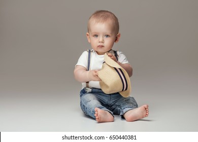 Cute baby boy posing in jeans. Adorable little child in studio.