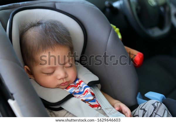 cute baby boy sleeping in car seat\
safety belt lock protection drive road trip\
travel