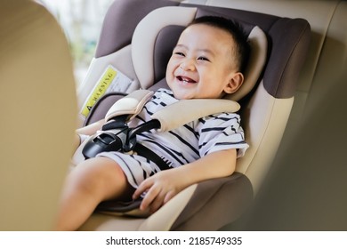 Cute Baby Boy Smiling In Safety Car Seat. Happy Baby On The Car. Child Transportation Safety Concept.