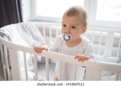 Cute baby boy standing in white round bed - Powered by Shutterstock