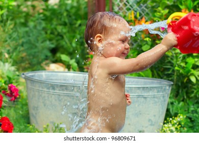 Cute Baby Boy Taking Water Procedures In Summer Garden