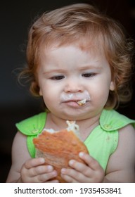 Cute Baby With Bread In Her Hands Eating. Cute Toddler Child Eating Sandwich, Self Feeding Concept. Funny Child Face