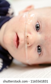 A Cute Baby With A Breathing Tube In Their Nose Receiving Medical Treatment.