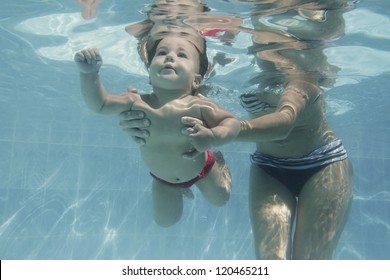 Cute Baby Child Swimming Under Water With Mother