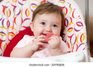 Cute Baby Child With Teething Ring Sitting In Craddle