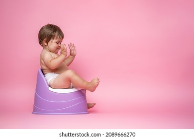 Cute Baby In A Diaper Sitting On A Potty. Toilet And Potty Training. A Small Child Gets Used To A Useful Skill. Hygiene.Baby Sitting On A Potty Toilet Stool Potty