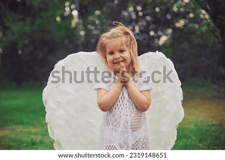 Cute baby dressed as an angel in the evening forest in Denmark