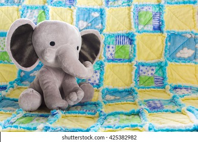 Cute Baby Elephant Stuffed Animal On A Colorful Quilt