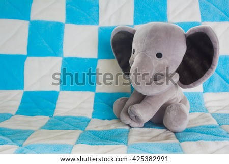 Cute Baby Elephant Stuffed Animal on a Blue Checkered Blanket