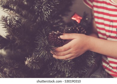Cute baby girl decorate and play around the chirstmas tree.