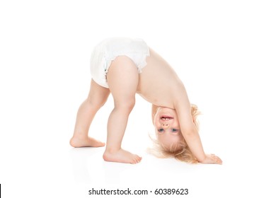 cute baby girl in diaper wants to turn somersaults isolated on white