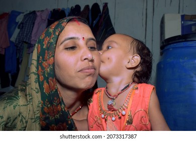 cute baby girl kissing her mother, rural home background