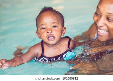 Cute Baby Girl Learning How To Swim In Indoor Pool.