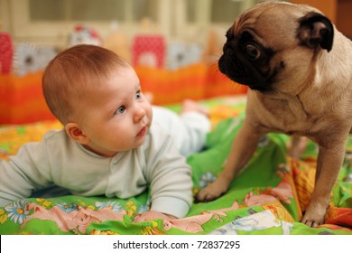 Cute Baby Girl Looking At Pug Dog. Closeup, Shallow DOF.