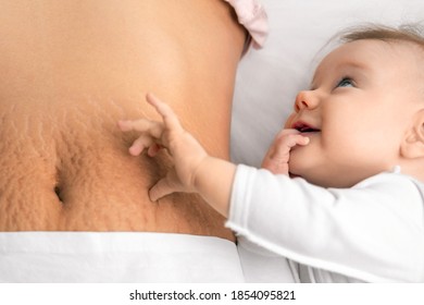 cute baby girl and mom's belly with stretch marks