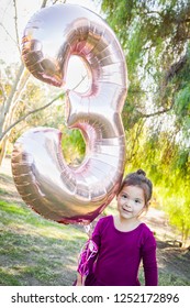 Cute Baby Girl Playing With Number Three Mylar Balloon Outdoors.