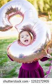 Cute Baby Girl Playing With Number Three Mylar Balloon Outdoors.