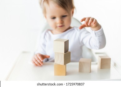 Cute Baby Girl Playing With Wooden Cubes. Little Child Building Tower. Construction Block For Kids. Montessori Educational Method. Selective Focus