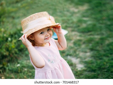 Cute baby girl portrait.Little girl in a straw hat smiles and looks at the camera space for text