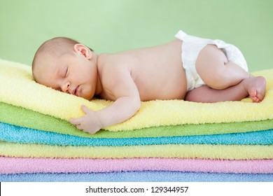 cute baby girl  sleeping on colourful towels