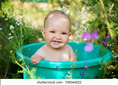 Cute Baby Girl Taking Water Procedures In Summer Garden