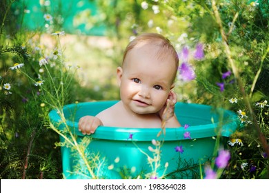 Cute Baby Girl Taking Water Procedures In Summer Garden