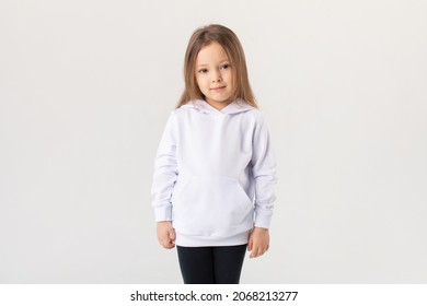 Cute Baby Girl In A White Blank Hoodie On A White Background. Kids Hoodies Mockup.