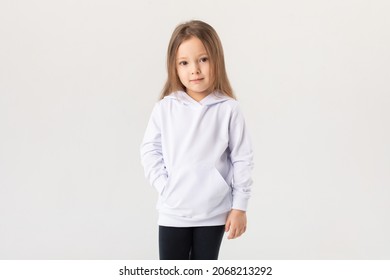 Cute Baby Girl In A White Blank Hoodie On A White Background. Kids Hoodies Mockup.