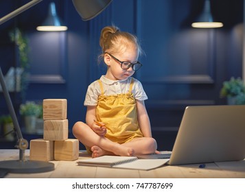 Cute baby girl working on a computer at home.