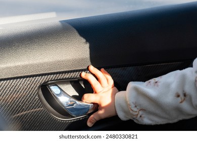 Cute baby hand pulling car door handle. Concept of need for child lock - Powered by Shutterstock