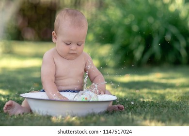 Cute Baby Hot Summer Day Playing With A Tub Of Water In The Garden 