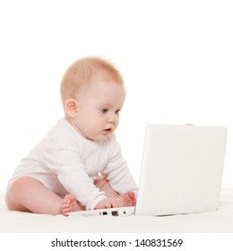 Cute baby with laptop on the white bed
